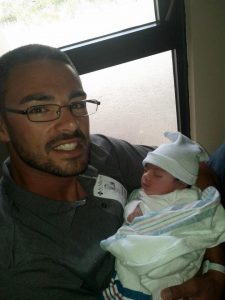 Captain Davey with his newborn daughter Iliana