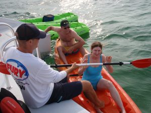Fury member helping couple get ready to kayak in Key West
