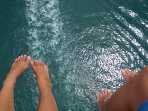 Top view of ocean and tourists' feet while parasailing in Key West