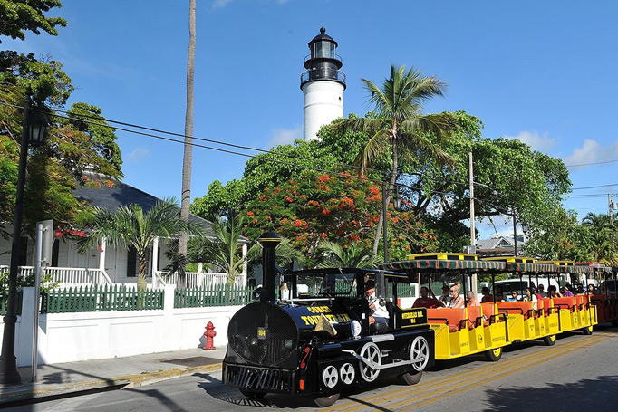 Conch Tour Train passing by the Key West Lighthouse