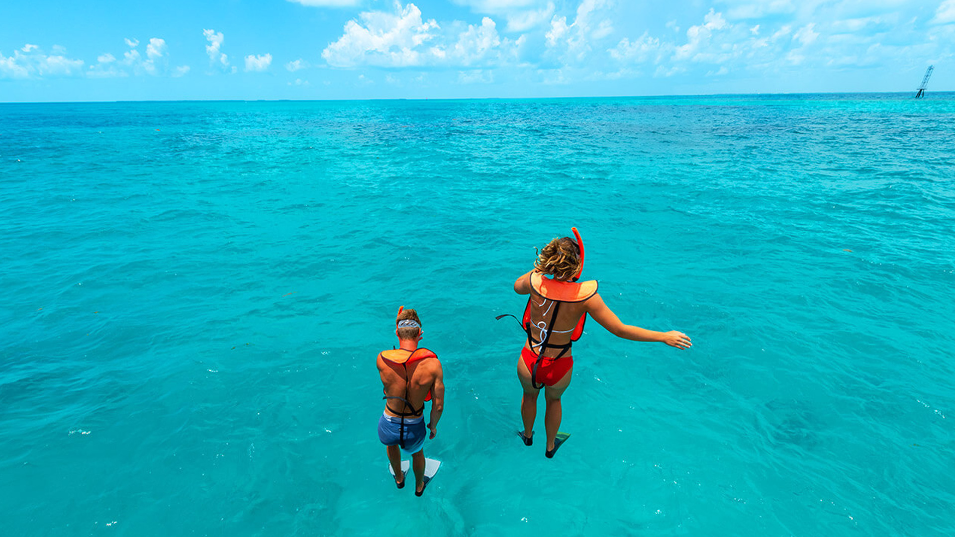 couple jumping into the water for key west reef snorkeling on a key west adventure