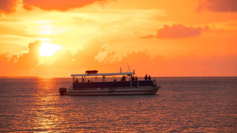 orange key west sunset with a sunset cruise boat