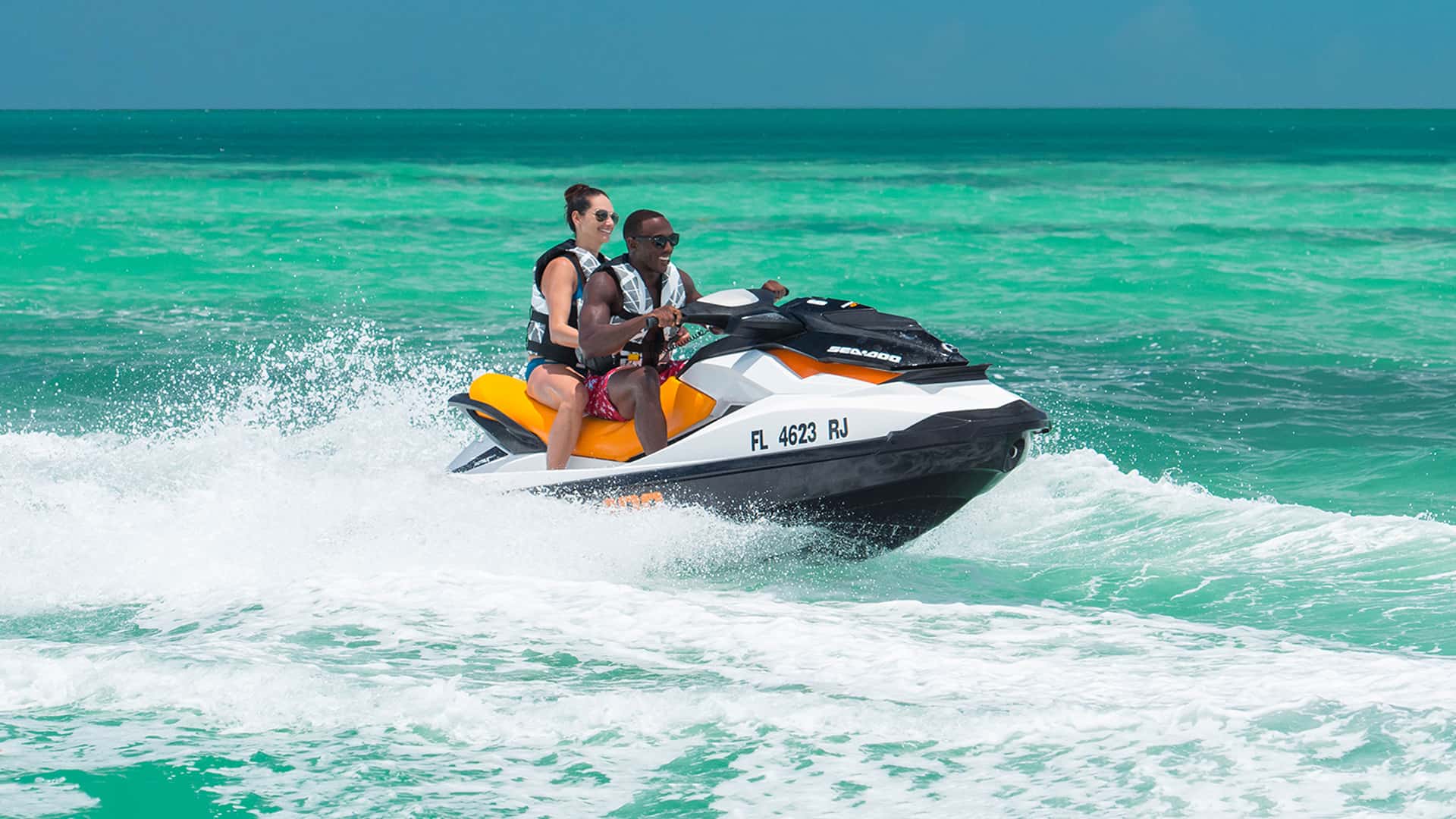 Image of couple aboard jet ski outside on water