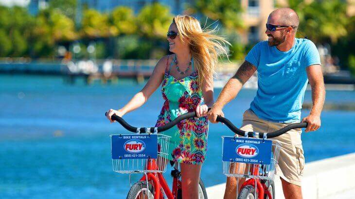Man and woman biking through Key West