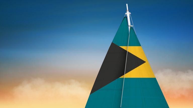 sail with bahamas flag with a sunset in the background