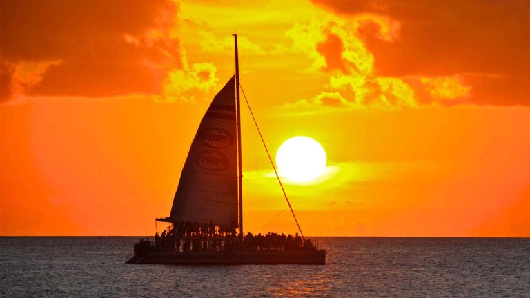 fury sunset sail ship with sunset in the background.